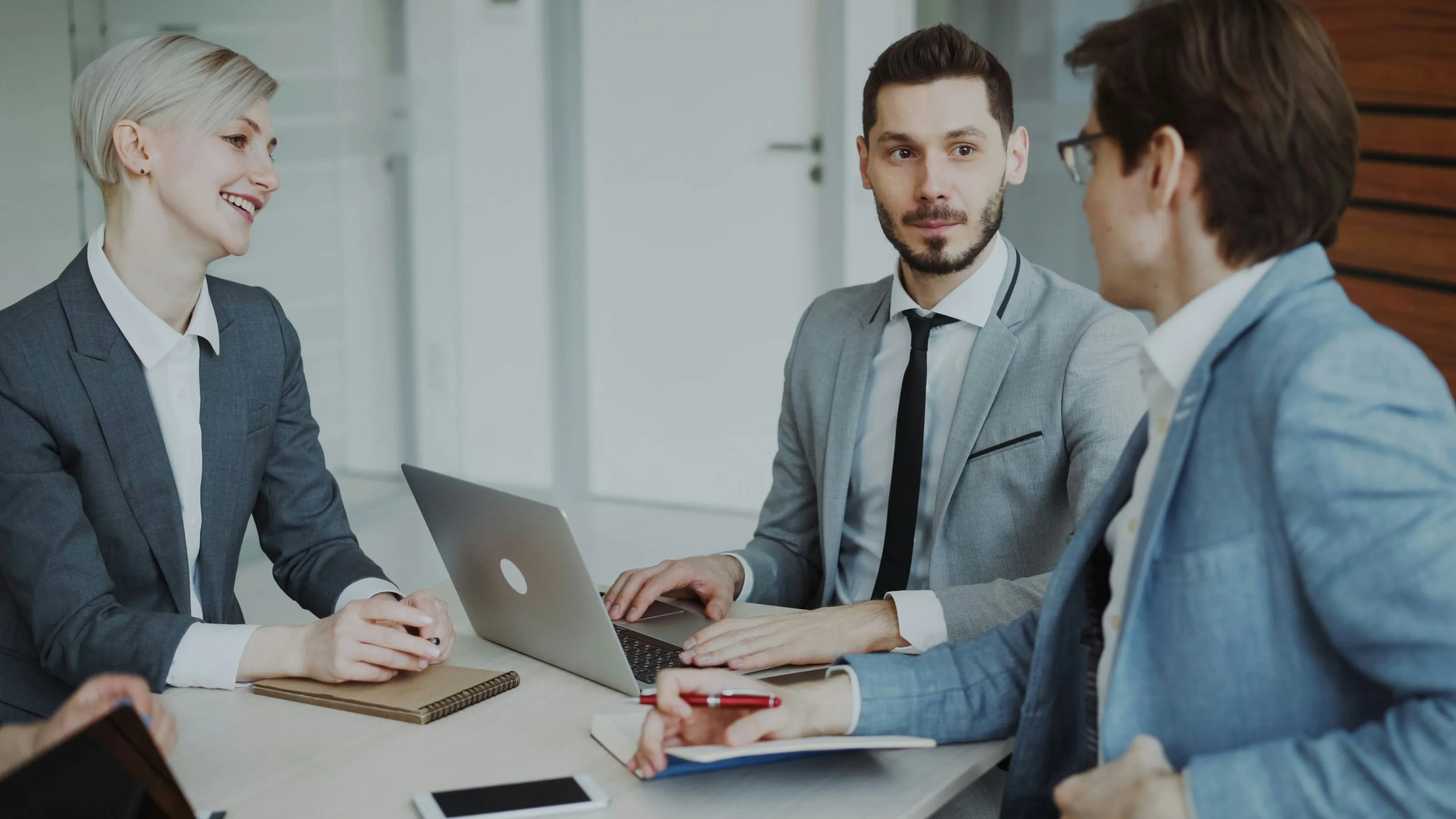 Professionals reviewing a file together around a meeting table